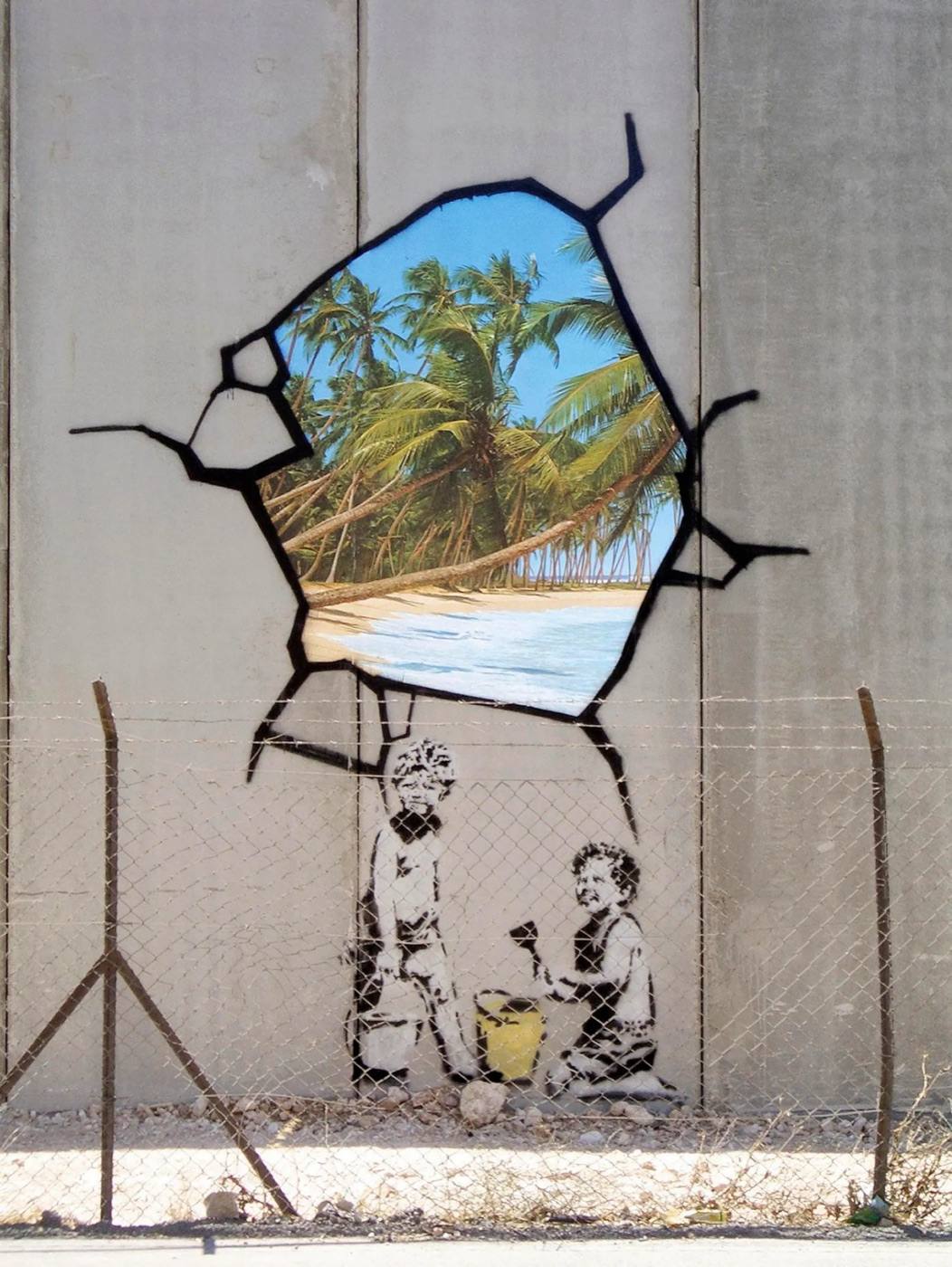 Banksy's mural on the West Bank barrier: two children with buckets and spades beneath a painted hole in the wall showing a beach.