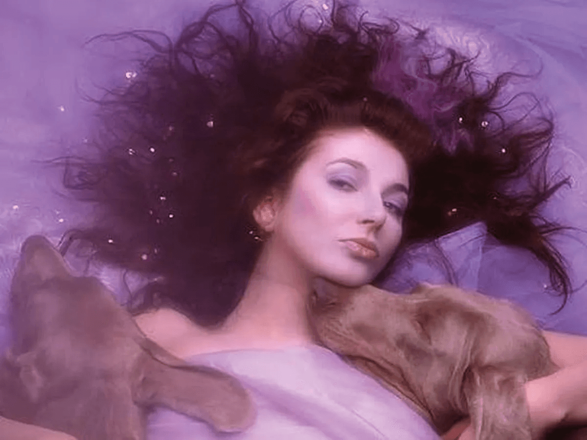 Kate Bush lying back among swathes of purple fabric, her hair spread around her.